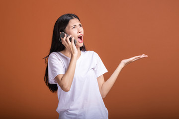 Woman using mobile phone isolated over orange background.