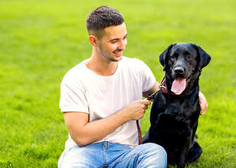 guy hugging with his dog labrador playing in the park