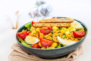 Salad of pasta, egg, smoked salmon tartare, salad and tomato, with a citrus vinaigrette sauce.