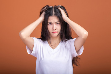 Thinking woman over orange background.