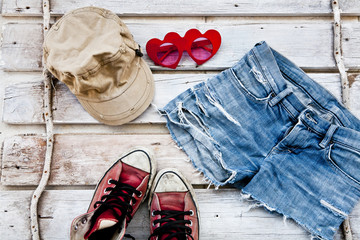 jean su legno con occhiali berretto e scarpe rosse
