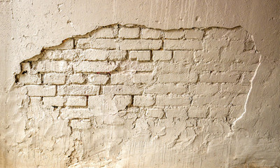 Texture of an old brick wall with peeling plaster