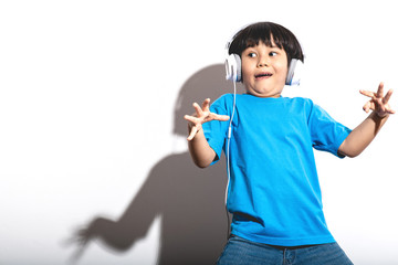 Young boy listening to music portrait in white background with hard light.