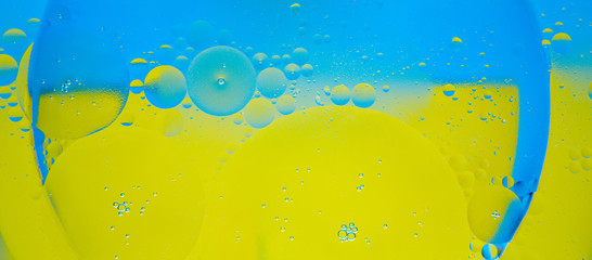 Circles of oil on water blue and yellow background. Abstract background for text.