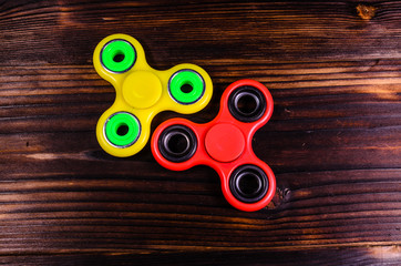 Two fidget spinners on wooden desk. Top view