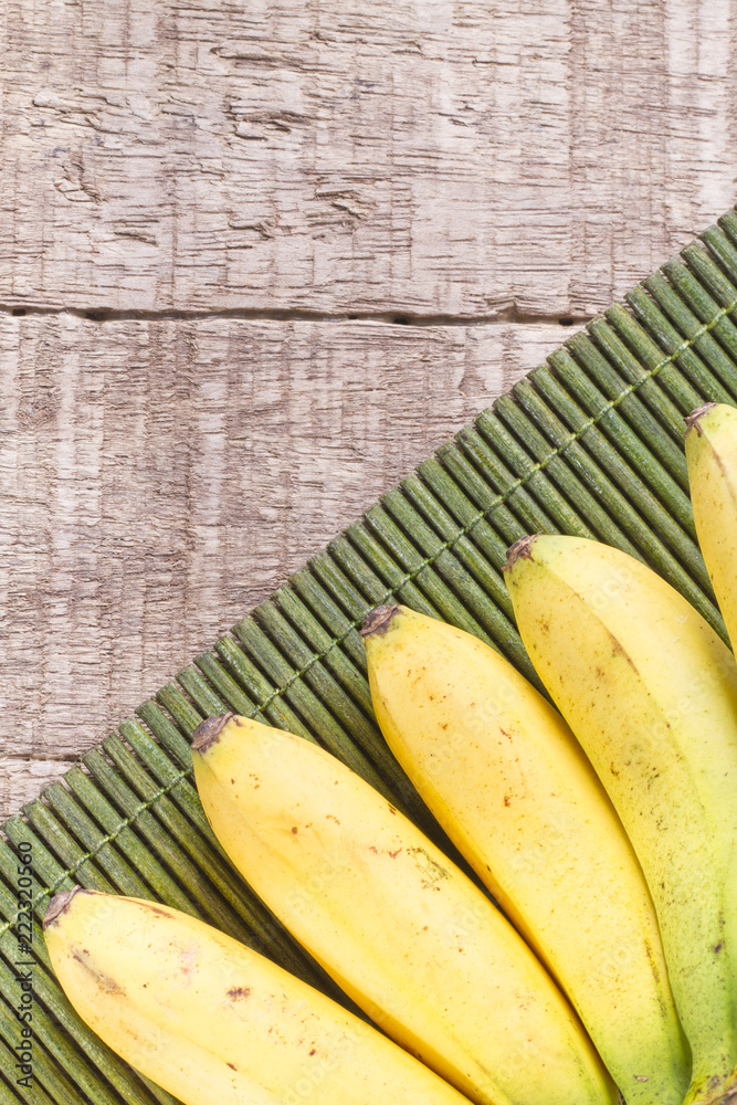 Wall mural banana fruit on the wooden table (musa × paradisiaca)