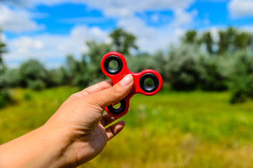 Red fidget spinner in female hand