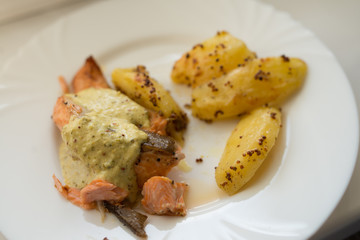 Grilled salmon with roasted sweet potato and wakame sauce on the white plate