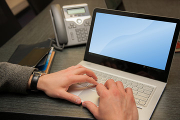Close-up of male hands typing on laptop keyboard