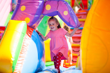 A cheerful child plays in an inflatable castle