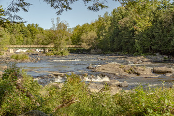 Fototapeta na wymiar Bridge corssing a river with some rapids