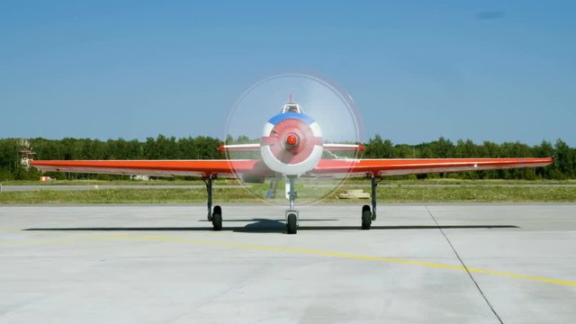 Medium shot of an old aircraft with turning propeller located at airport. 4K