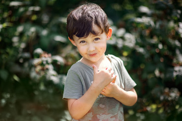 boy with dirty face after eating raspberries