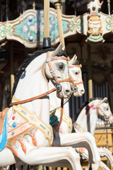 Fototapeta na wymiar White horses of the antique carousel