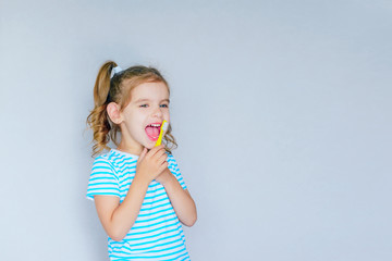 Beautiful baby girl brushing her teeth. Baby girl brushing her teeth and singing a favorite song.  Health care, dental hygiene, people and beauty concept. Mockup, free spase. Selective focus. 
