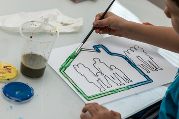 Toddler boy painting on paper