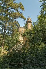 Obraz premium An old, historic defensive tower hidden between trees.