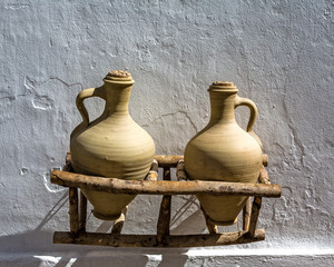 Pair of earthenware pots in wooden frame against white wall