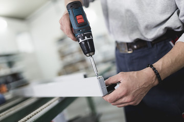 Manual worker assembling PVC doors and windows. Manufacturing jobs. Selective focus. Factory for aluminum and PVC windows and doors production.