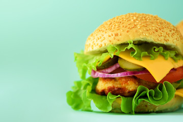 Homemade cheese burger or hamburger on blue background with copy space. Fast food for breakfast, lunch.