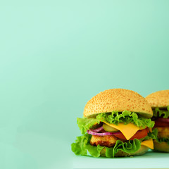 Fast food concept. Square crop. Juicy homemade hamburgers on blue background. Take away meal. Unhealthy diet frame with copy space