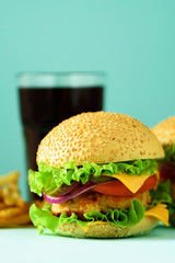 Fast food concept. Juicy homemade hamburgers on blue background. Take away meal. Unhealthy diet frame with copy space