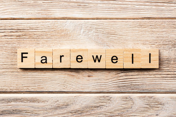 farewell word written on wood block. farewell text on table, concept