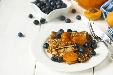 Homemade crepes served with apricot jam fresh blueberries.