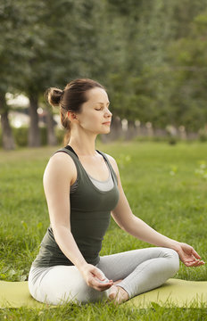 young slender girl meditating in lotus position. breathing exercises. practice of yoga.

young woman doing breathing exercises.