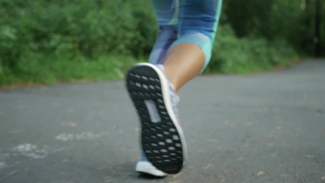 close-up, sporty woman runs in the park