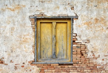 Yellow wooden window with crack brick wall texture background