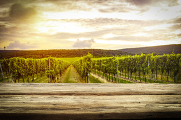 old rustic table in a beautiful vineyard at sunset  