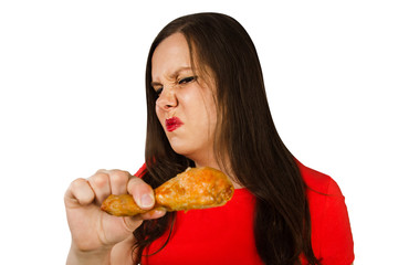 Young pretty woman holds spoiled grilled chicken leg isolated on a white background.