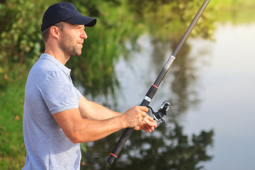 Fishing. Fisherman on river with fishing rod. Outdoor fishing in lake during sunset. Hunting and hobby