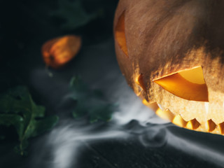 Happy Halloween and scary pumpkin exhaling smoke or steam with copy space. Deadly breath