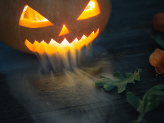 Fototapeta premium Happy Halloween and scary pumpkin exhaling smoke or steam with copy space. Deadly breath