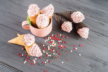 Sweet ice cream in a waffle horn on wooden background. Top view. Copy space