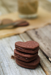 Delicious heart shape homemade chocolate cookies on rustic wooden background. Sweet chocolate dessert or snack.