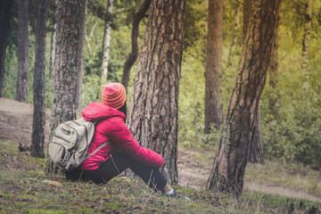 Woman tourism. Back of traveler in the forest looks for the road. Beautiful young woman is traveling and resting in the forest