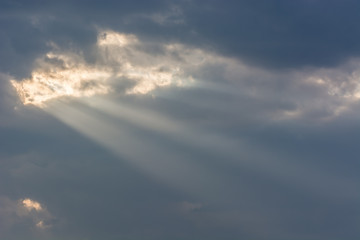 Fototapeta na wymiar Sun Rays Passing Through a Hole in the Clouds