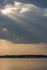 Beautiful Sun Rays Piercing the Grey Clouds and Falling on the Silent Lake
