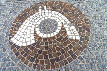 The emblem of a post office  in the form of a mosaic on the sidewalk.