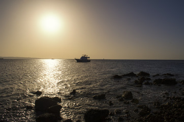 Fototapeta na wymiar sunset over the sea with a yacht