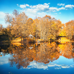 Sunny autumn landscape with blue sky over the lake