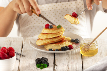 young man eating pancakes with fruit