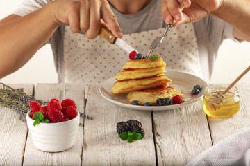 young man eating pancakes with fruit