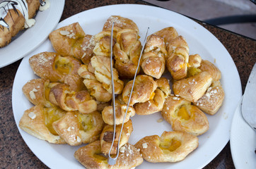 many different rolls on plates on a large table