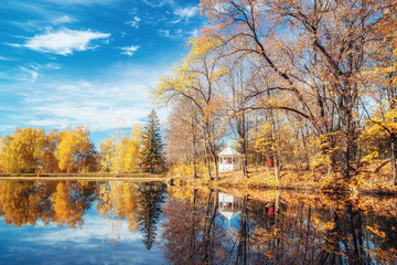 Sunny autumn landscape with blue sky over the lake