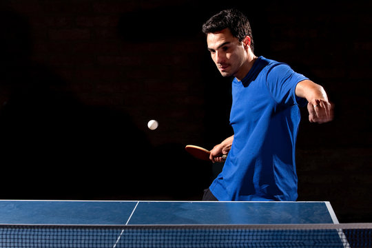 Deportista Jugando Tenis De Mesa Sobre Fondo Negro.