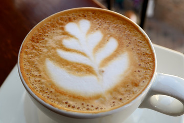 Closed Up Hot Cappuccino Coffee with Latte Art in a White Cup 